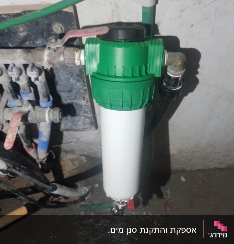 מסנן מים ירוק ולבן מחובר לצנרת